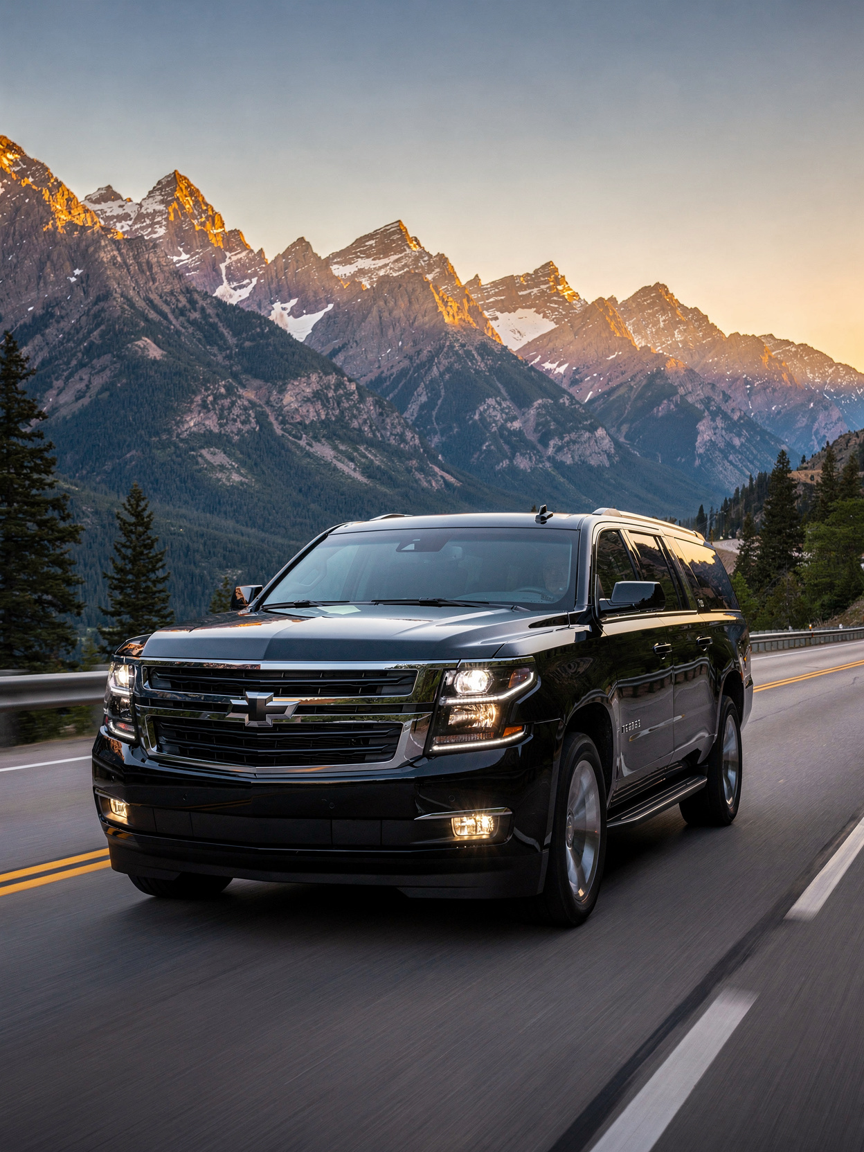 A black executive SUV driving along a Colorado mountain highway at sunset